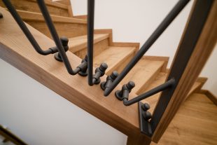 Handmade stairs made of wood and black metal. Loft style in the house. High quality photo